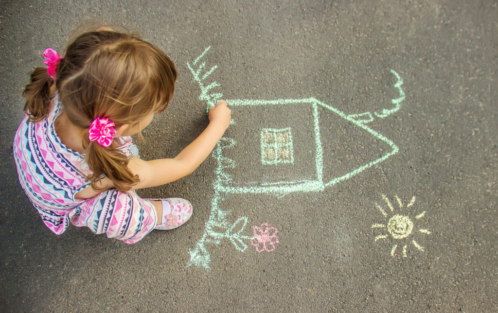 little girl making an art in street floor